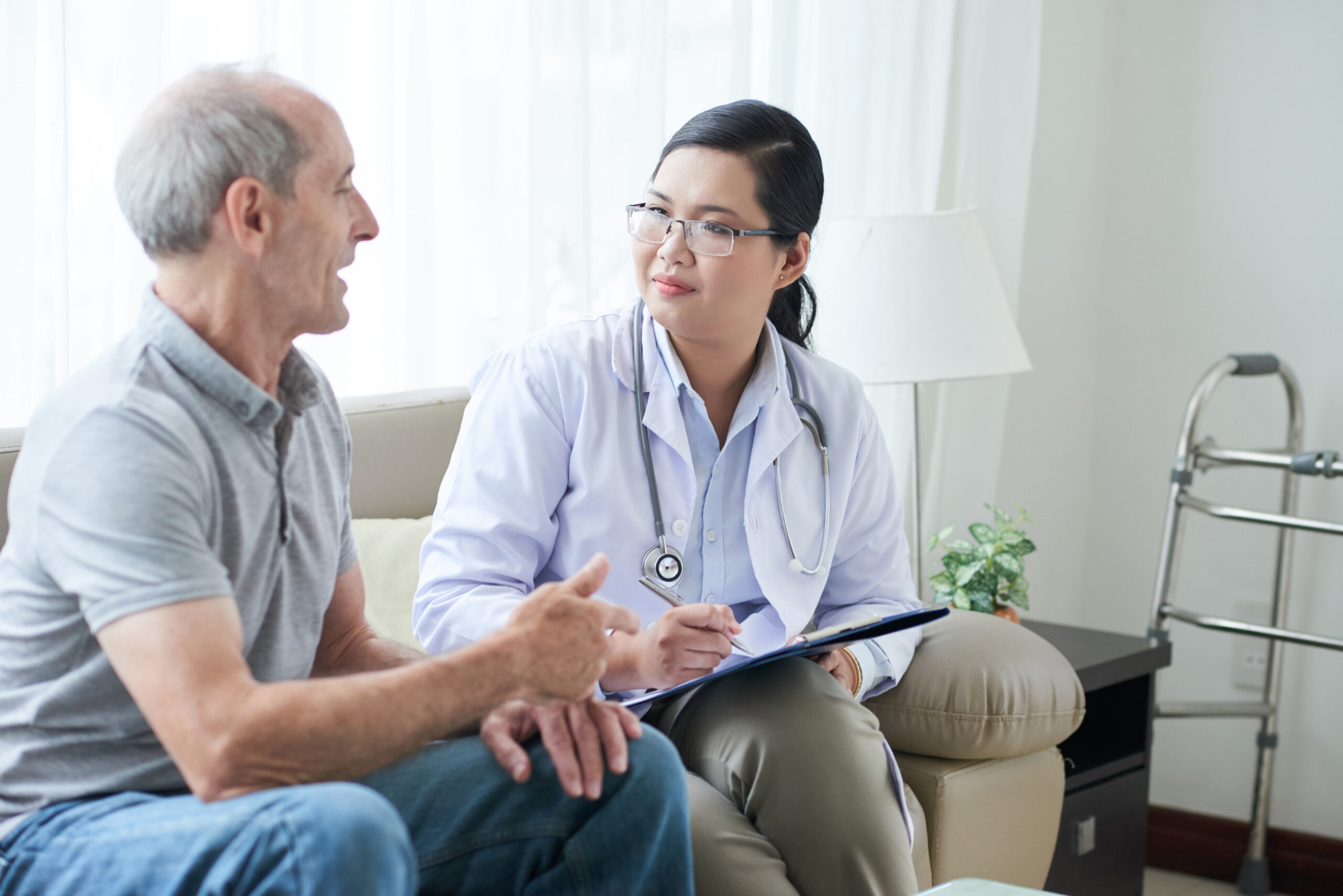 doctor talking to senior client at home